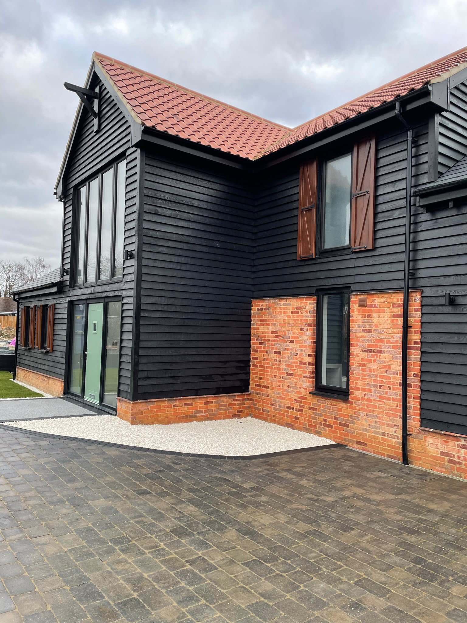 House cladding installation: larch timber cladding installed and spray finished black on a home