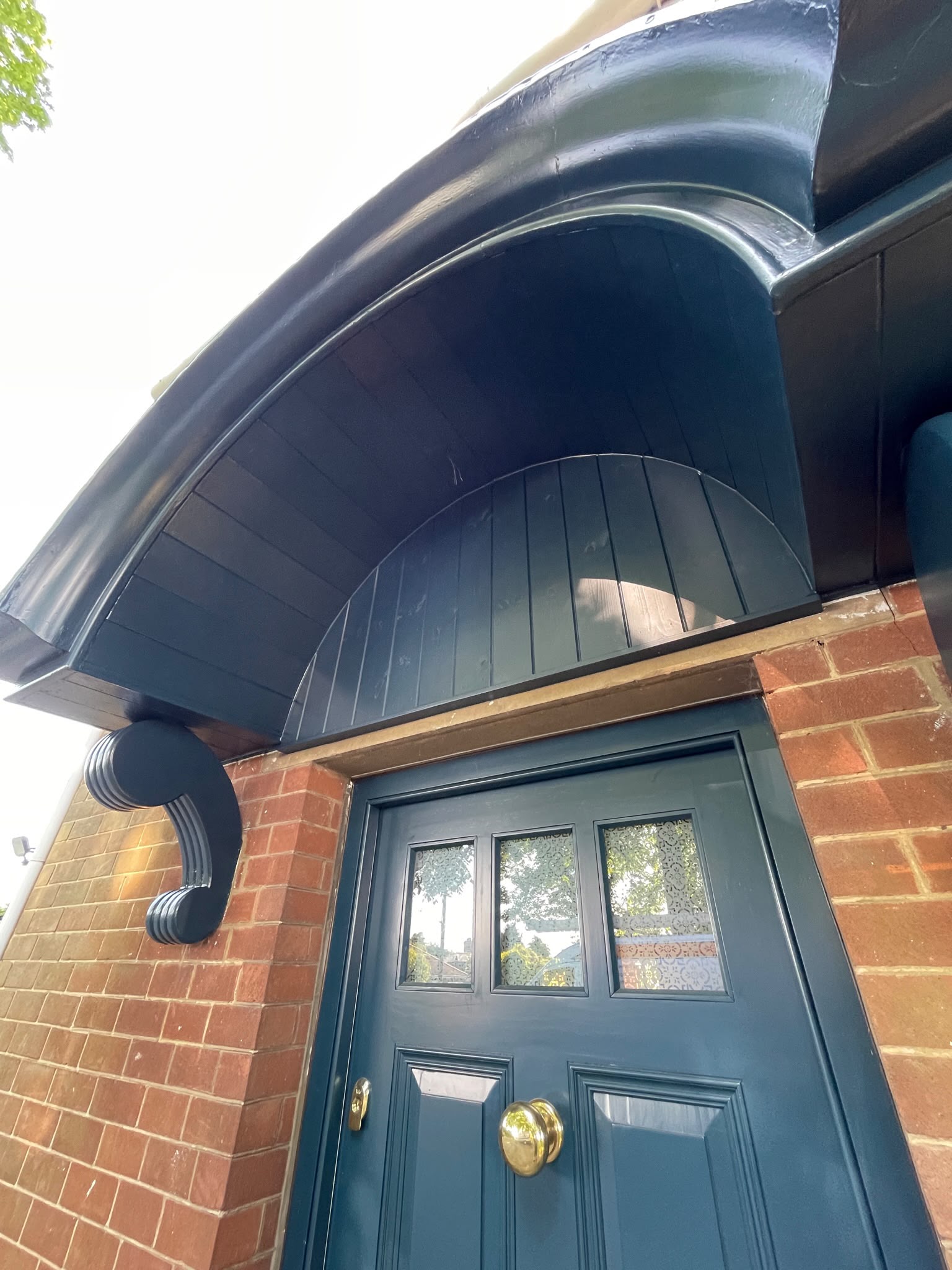 Front door spraying: door and canopy sprayed deep heritage green on a brick house