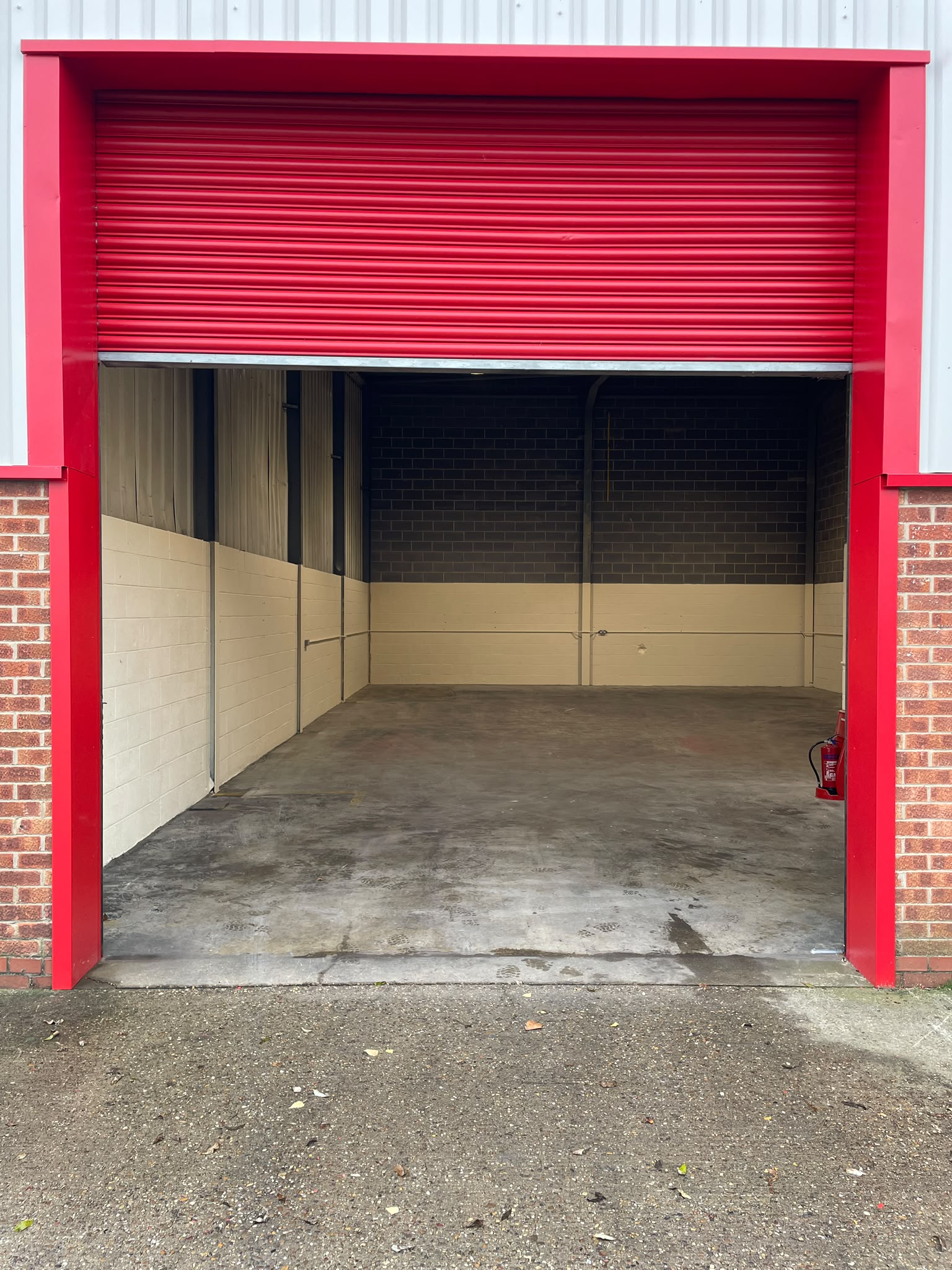 Roller shutter spraying: commercial unit entrance shutter recoated red, inside and out