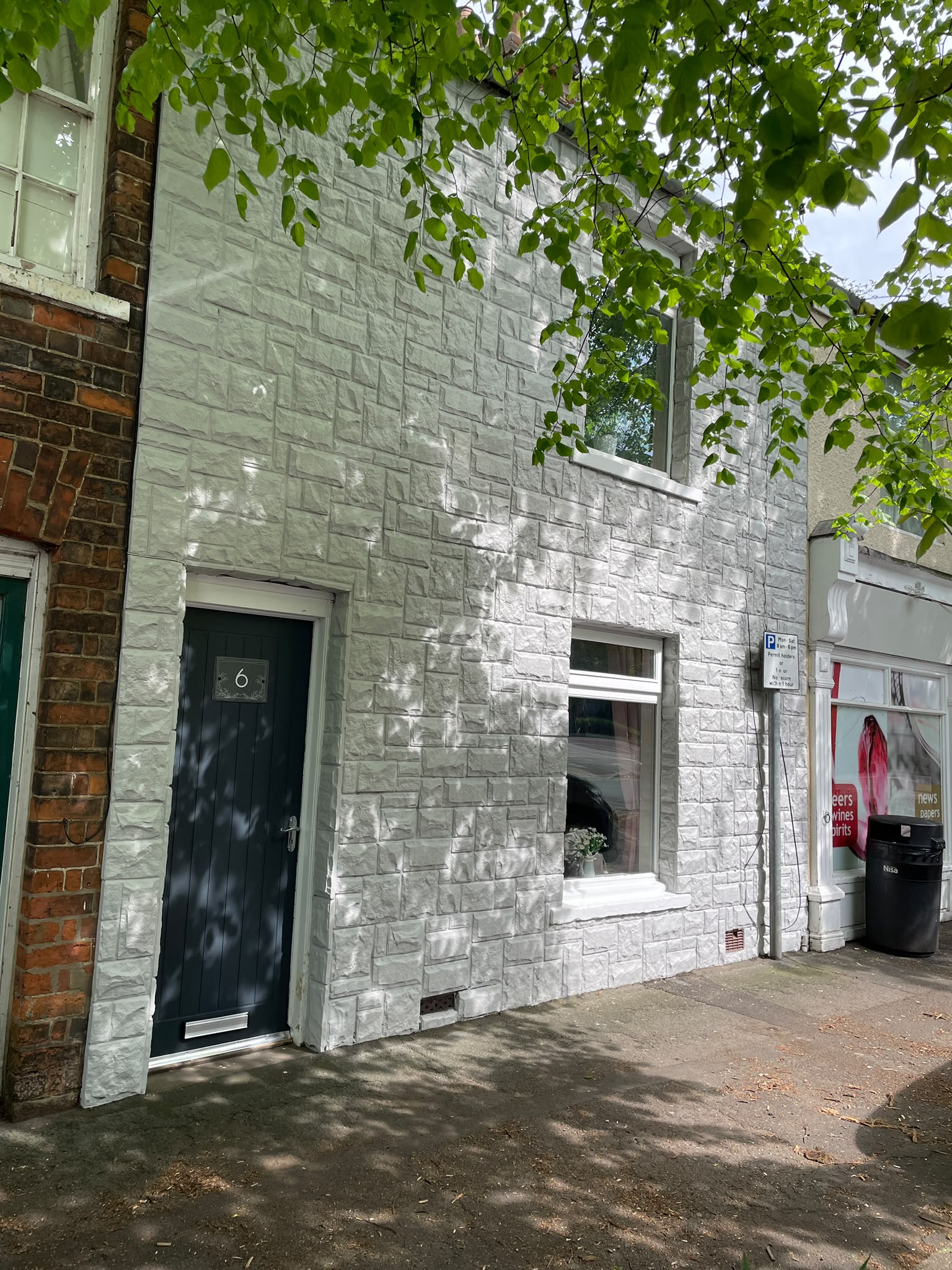 Exterior house spraying: painted brick terrace frontage sprayed crisp white with a black door