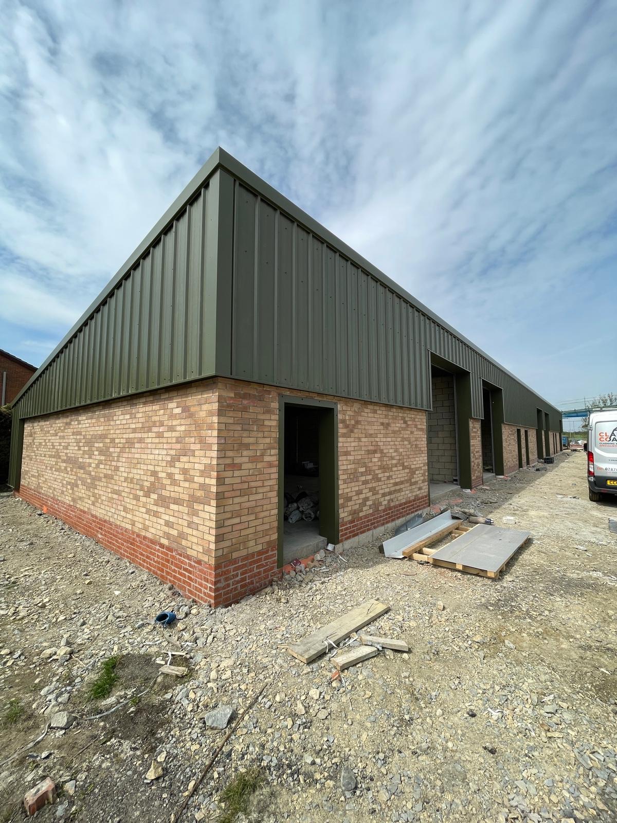 Commercial cladding installation: freshly installed green profiled cladding on a new build commercial unit