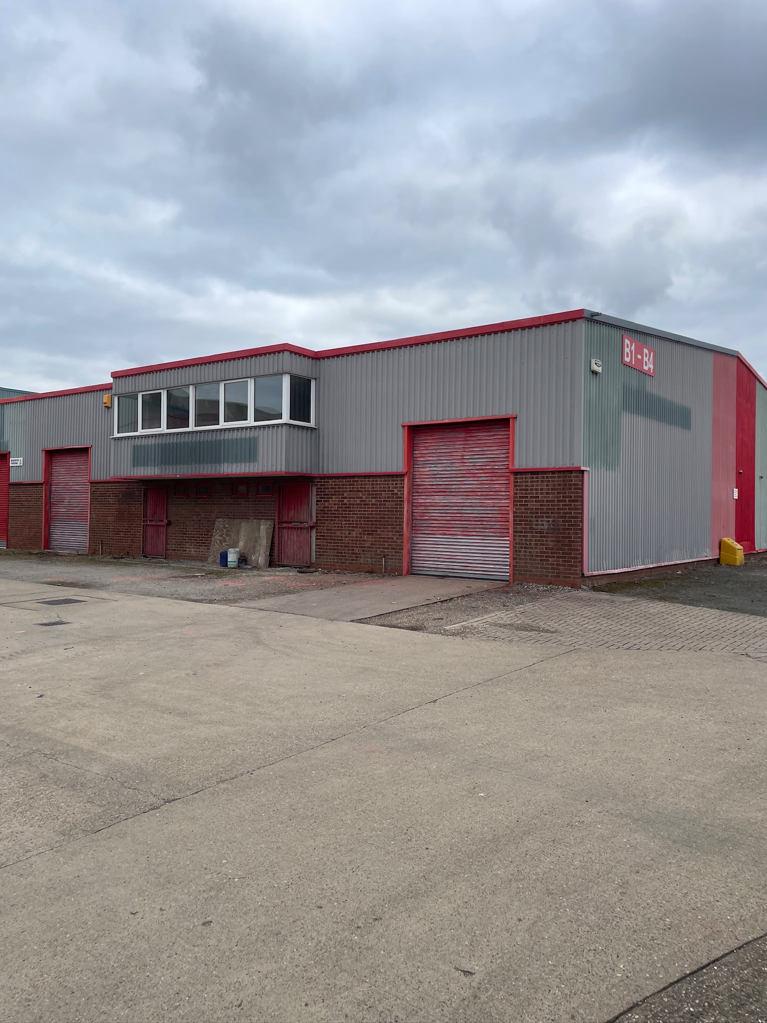 Commercial cladding spraying: industrial unit elevation before and after a full on site respray. Before.